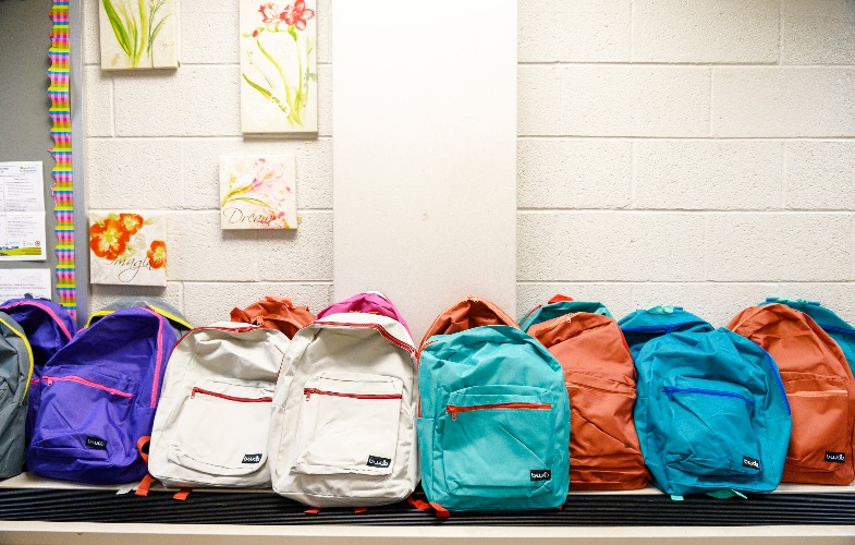 group of backpacks lined up in hallway