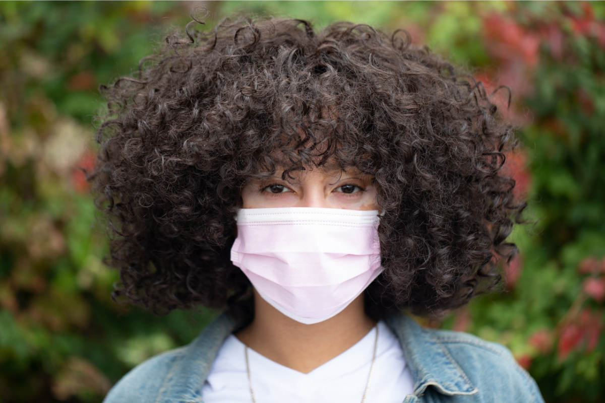 woman with afro wearing face mask