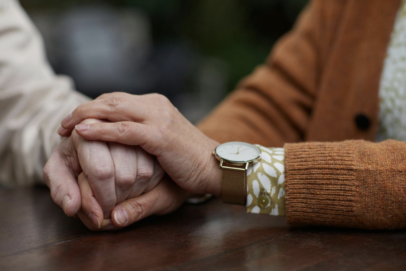 older woman holding the hands of an older man while discussing planned giving